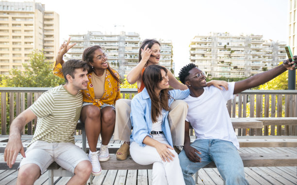 多种族朋友在城市里用手机自拍——友谊、幸福、快乐的概念图片下载