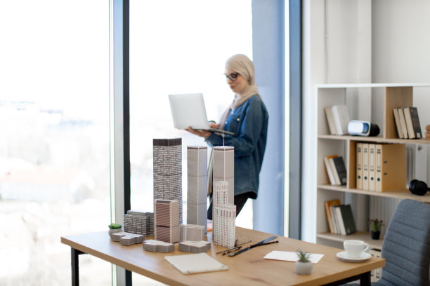 女商人拿着笔记本电脑站在办公室里图片下载