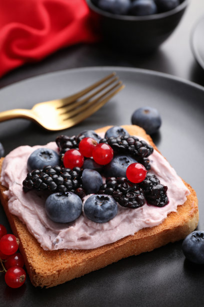 美味的三明治，奶油奶酪和浆果放在黑色盘子里，特写图片下载