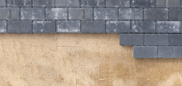 在沙地人行道上铺设水泥路面的俯视图。房子的改进。背景纹理横幅图片下载