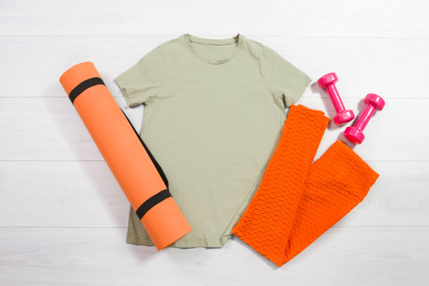 卡其色女性运动健身t恤模型平放在木制背景上。夏季普拉提拉伸配件。运动裤，瑜伽垫，正面正面的t恤。t恤模板空白复制空间图片下载