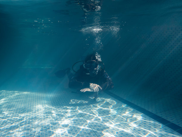 穿着潜水服的人在泳池里练习。图片下载