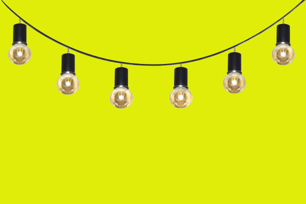 黄色背景上，一排灯泡挂在电线上。图片下载