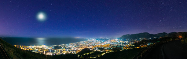 Terracina,意大利。顶视图天际线城市景观城市在晚上的夜间照明。全景，全景。令人惊叹的明亮的蓝色夜空与满月在拉丁省图片下载