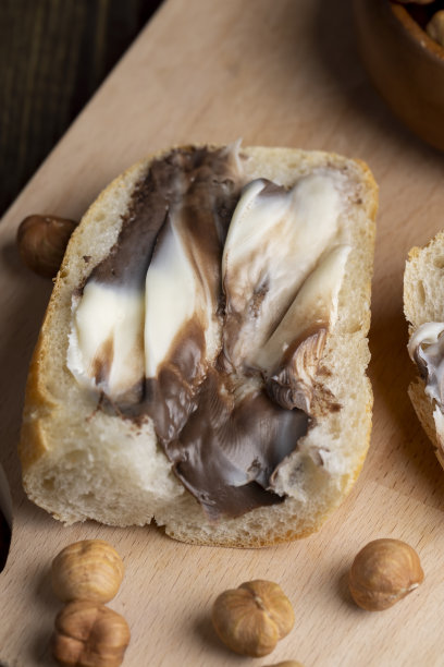 桌上放着涂了巧克力黄油的面包片图片下载