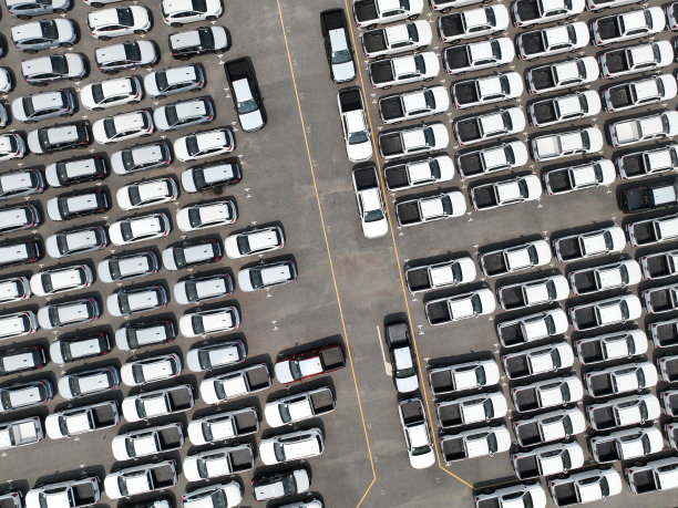 工厂停车场的新车库存鸟瞰图。上图是一排停放的汽车。汽车行业。物流业务。在仓库进出口新车。港口码头的大停车场图片下载