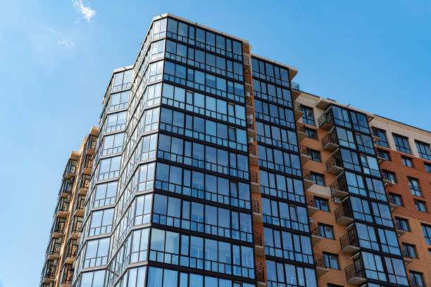 现代豪华公寓楼。现代公寓大楼的正面。蓝天为背景图片下载