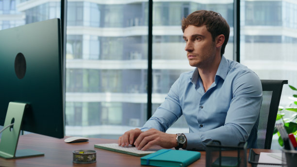 专注的商人在办公室使用电脑。严重员工打字键盘图片下载