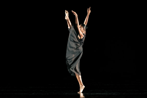 黑人年轻女子在黑暗的舞台上表演现代舞图片下载