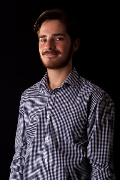 年轻的职业成年人微笑着，快乐而满足。色彩表现戏剧性效果，深色和忧郁系列。工作室拍摄。图片下载