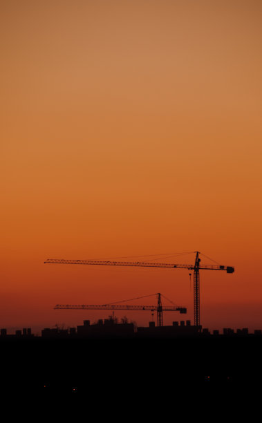 橙色的夕阳和建筑起重机图片下载