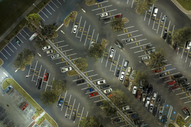俯视图，许多汽车停在夜间照明明亮的停车场前的杂货店购物中心。消费主义与市场经济的概念图片下载
