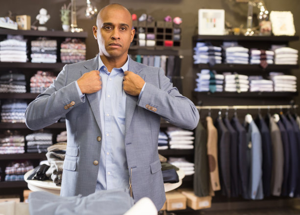 男子在服装店挑选西装外套图片下载
