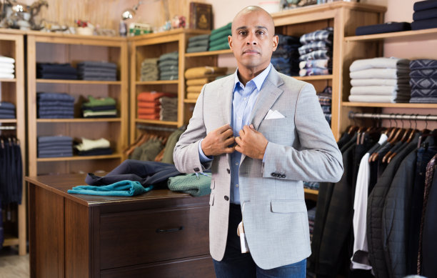 男子在服装店挑选西装外套图片下载