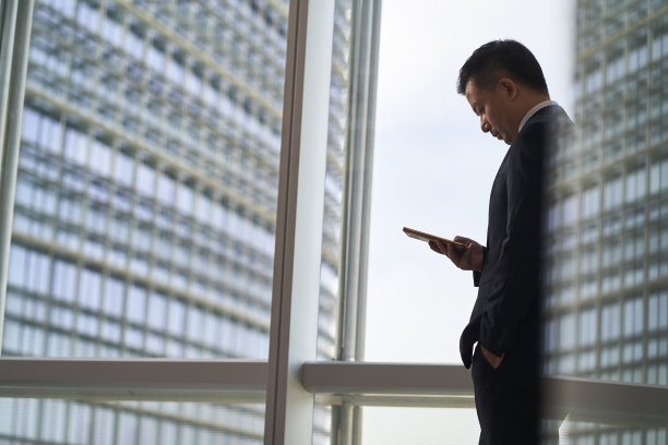 亚洲商人在办公室看手机图片下载