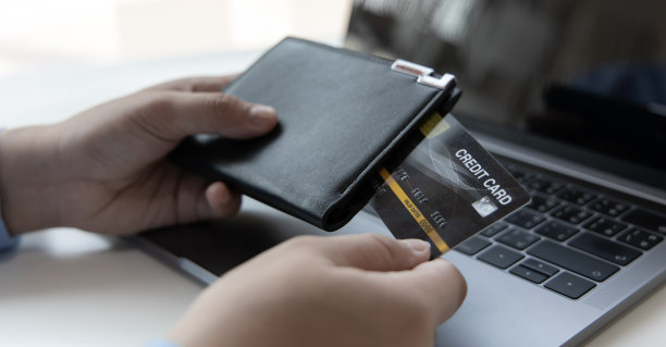 一位年轻的亚洲男子正在拿信用卡图片下载