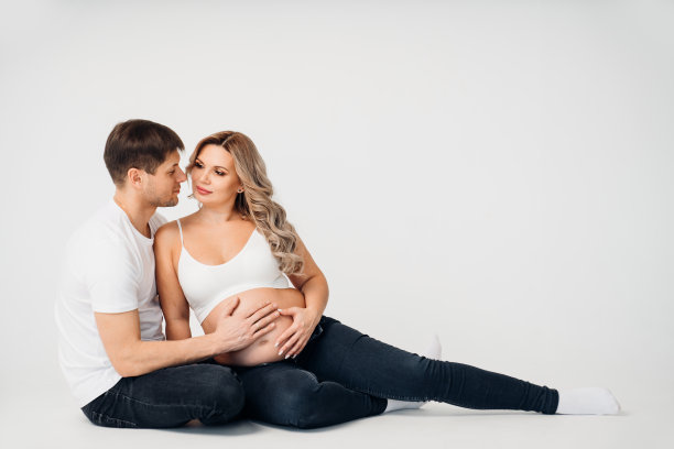 在照相馆里，一对夫妇坐在一幅环形画板的地板上等孩子图片下载