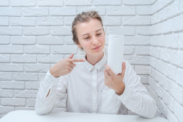 女人向你推销白砖墙背景的化妆品图片下载