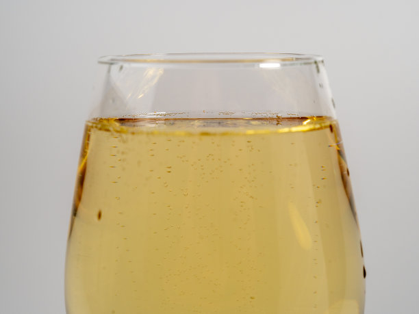 浅色背景下的一杯白葡萄酒。图片下载