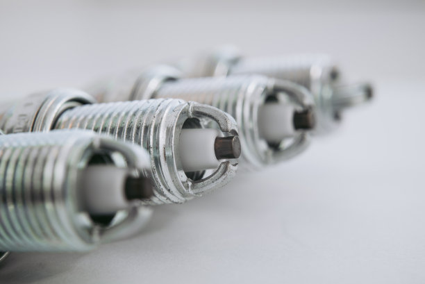 汽车服务。一套新的汽车火花塞作为机动车辆上白的备件。马达特写用的一组蜡烛图片下载