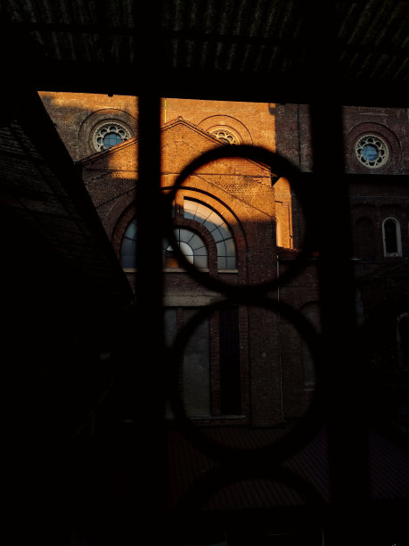 通过圆形门框看到的建筑物的垂直图像图片下载