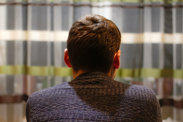 年轻人坐在家里思考的背影。迷失在思绪中，想着解决问题，感到孤独，做出重要决定，心理问题。心理健康。焦距不清图片下载