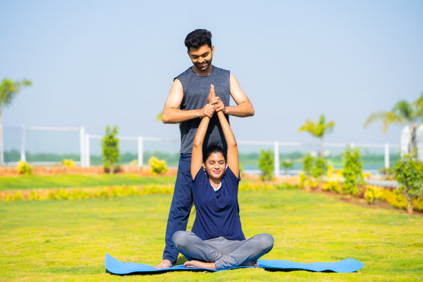 教练教瑜伽姿势或姿势的女孩在公园-瑜伽大师的概念，私人教练和专业职业。图片下载