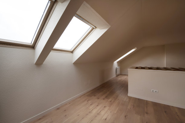 空荡荡的房间，栗色地板，奶油色墙壁，倾斜的天花板上有天窗图片下载