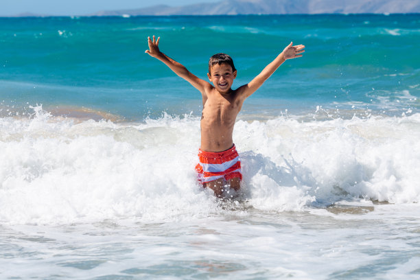 快乐的男孩在暑假里喜欢玩海浪图片下载
