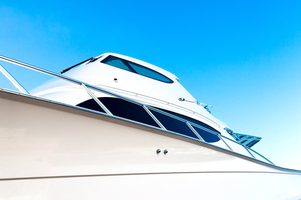 一艘豪华机动游艇的船壳，映衬着蓝天，阳光照在角落里，底景。图片下载