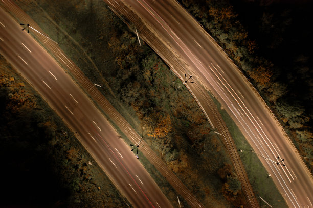 俯视图到道路。浪漫的夜晚航拍照片的汽车行驶。城市夜晚道路上的灯光。背景风景公路无人机视图。有轨电车铁路图片下载