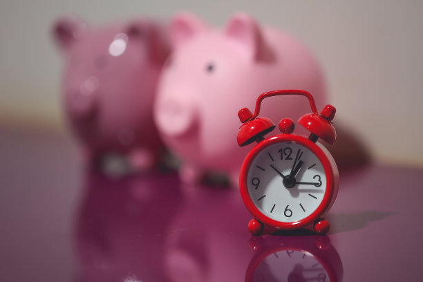 两个储蓄罐和一个红色闹钟。金融的概念。图片下载