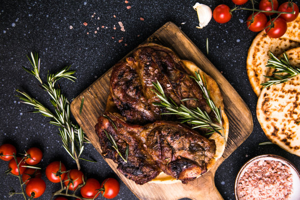 牛排。切片烤牛排纽约或Ribeye与香料迷迭香和胡椒黑色板。前视图。图片下载