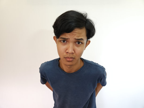 穿着灰色t恤的亚洲人在白色的背景上偷窥图片下载