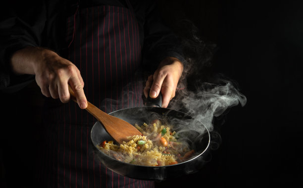 煮新鲜蔬菜和面条。厨师在热煎锅里翻动食物。泰国街头小吃。图片下载