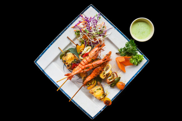 烤虾与鱼串上孤立的黑色背景顶部视图图片下载