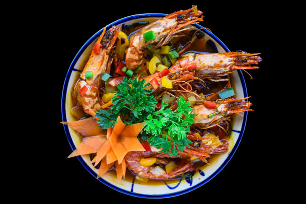 盐炒虾与酱汁和蔬菜孤立在黑色背景图片下载