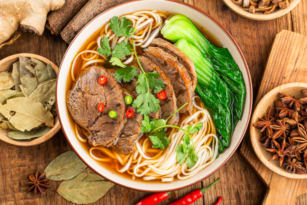 木桌上一碗红辣味汤牛肉面图片下载