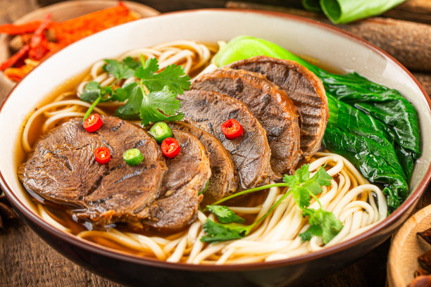 木桌上一碗红辣味汤牛肉面图片下载