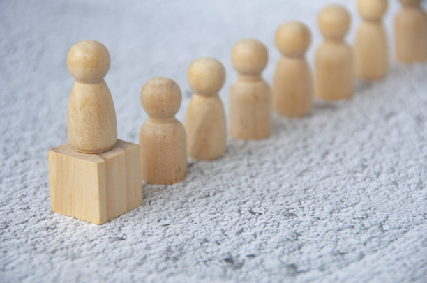 木块上的红色木头人，代表一个领导着另一个人。领导的概念。图片下载