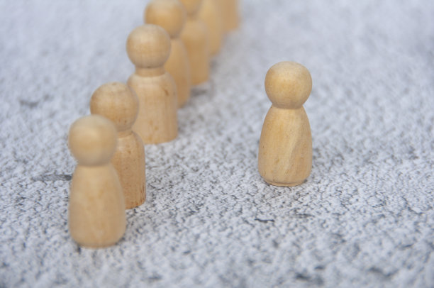 一个木头人像从其余的人像中迈出第一步，代表勇气。领导的概念图片下载