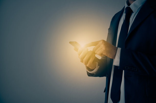 商人的手和手指触摸手机屏幕上倾斜姿势复古的色调图片下载