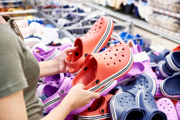 一位女士在商店挑选塑料拖鞋图片下载