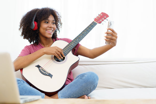 女人喜欢弹吉他和唱歌。图片下载
