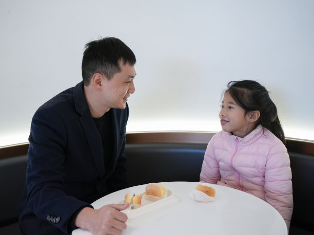 父亲和女儿在一起吃面包图片下载