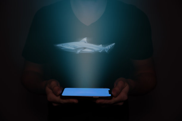 一个未来的人拿着一只投射在上面的鲨鱼。新技术。图片下载