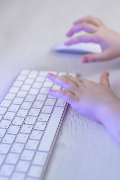 孩子们的手正在键盘上打字。这个孩子玩电脑游戏。图片下载