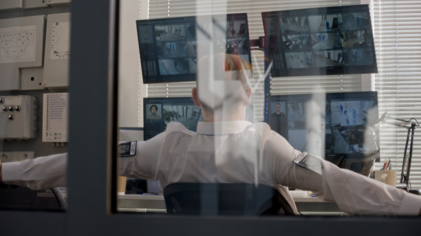 安保人员控制着监控摄像头，并向后倾斜图片下载