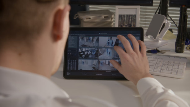 保安在平板电脑上监控闭路电视摄像头图片下载