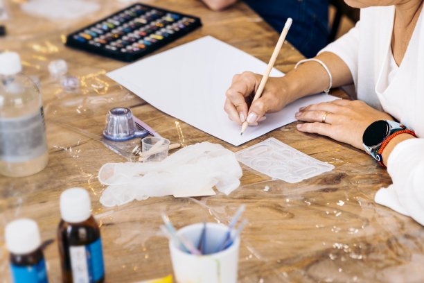首饰车间用环氧树脂。一个女人用手画草图的特写。图片下载